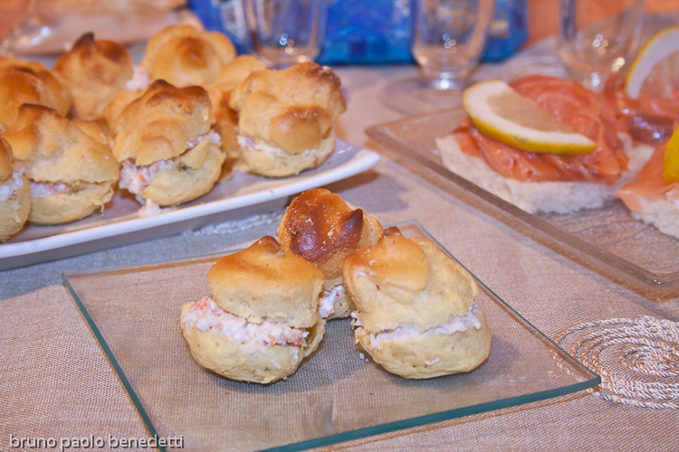 finger food buffet: crab beignets and smoked salmon canapes on glass and white dish